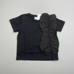 black top with a distinct and voluminous ruffled detail